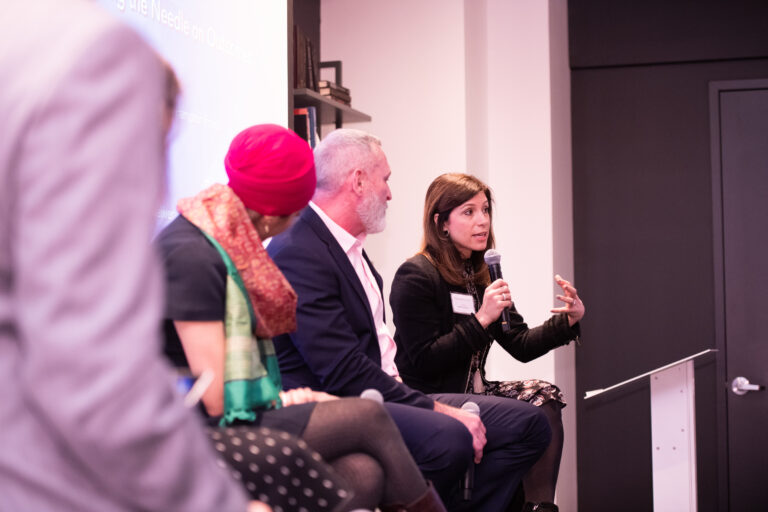 woman talking on a panel with other speakers