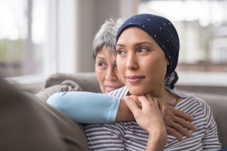 An Asian woman in her 60s embraces her mid-30s daughter who is battling cancer