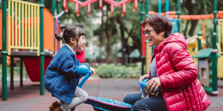 woman plays with her daughter on playground equipment