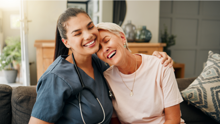 healthcare work laughing and hugging older woman