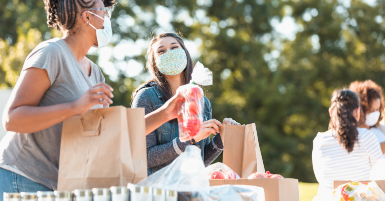 Masked up women hand out food
